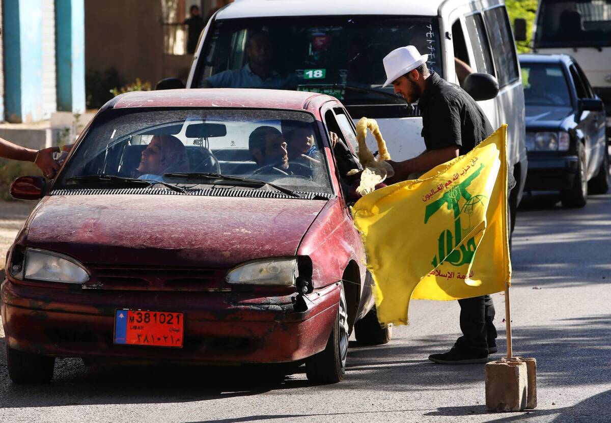 Hezbollah supporters in the Lebanese village of Bazzalieh distribute sweets to passersby to celebrate the fall of the Syrian town of Qusair to Hezbollah fighters and forces loyal to Syrian President Bashar Assad.