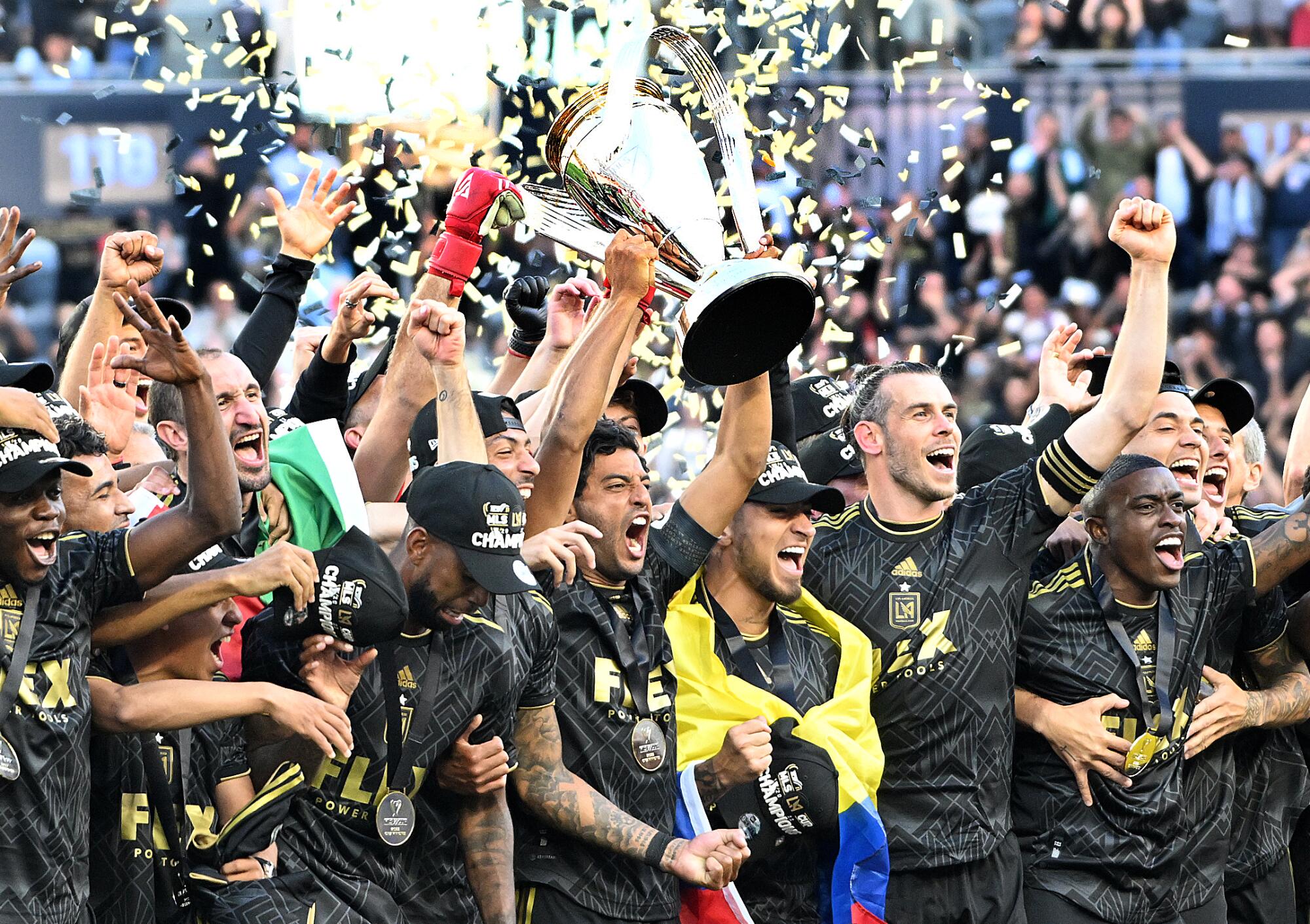 LAFC players celebrate after winning the MLS Cup, holding up the trophy