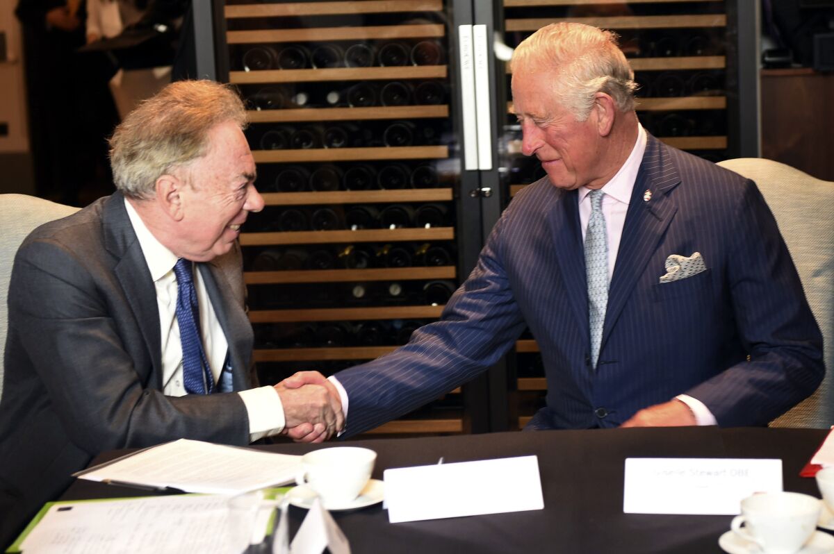 Britain's Prince Charles shakes hands with Andrew Lloyd Webber while they are seated in 2018. 