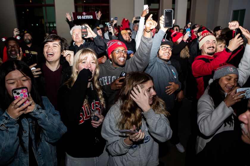 San Diego, CA - March 26: San Diego State fans cheer as the buses carrying the Aztecs' players and coaches arrive back on campus outside the Fowler Athletic Center on Sunday, March 26, 2023 in San Diego, CA. The Aztecs defeated Creighton 57-56 to advance to the Final Four. (Meg McLaughlin / The San Diego Union-Tribune)