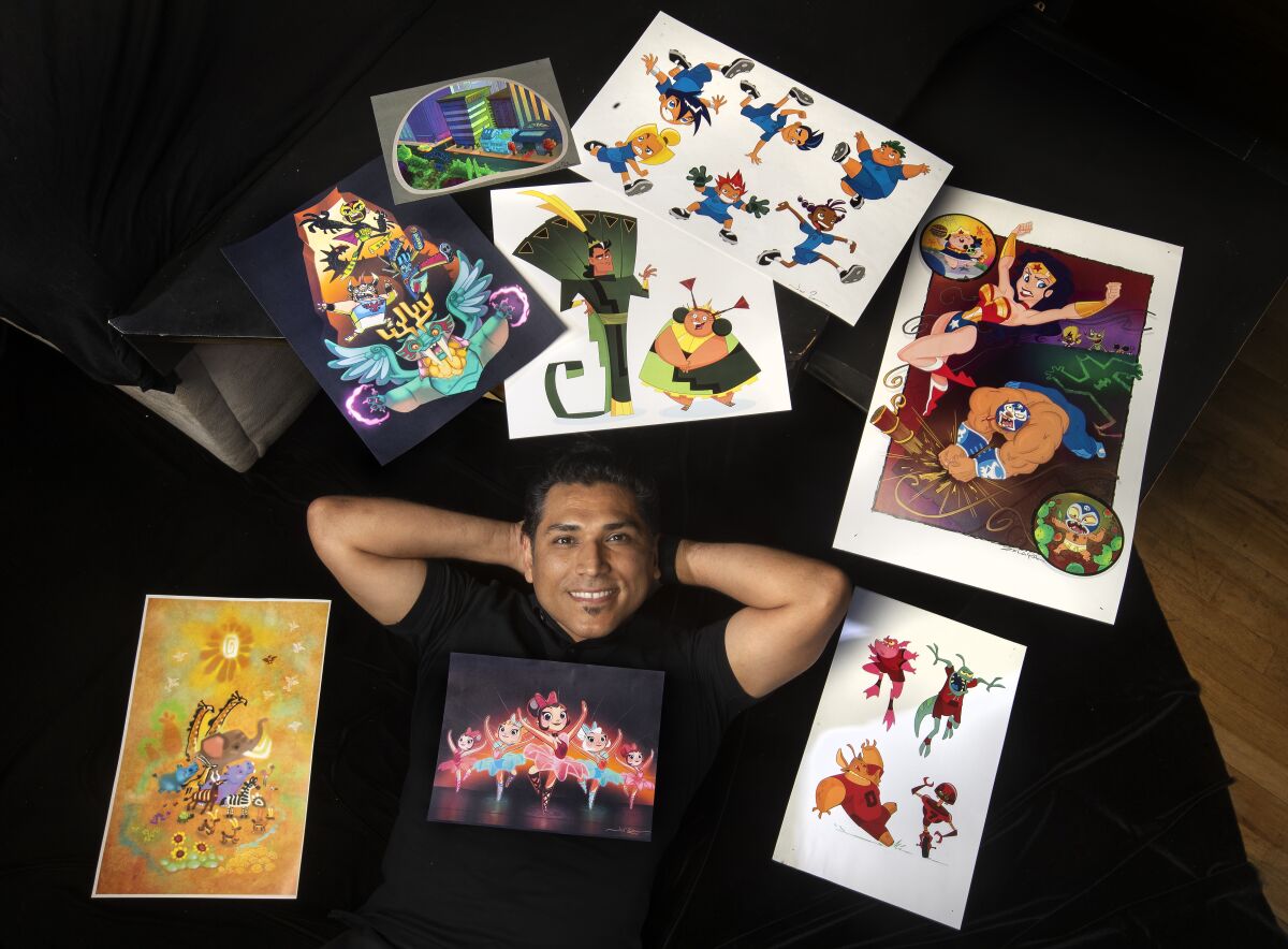 An artist is photographed next to some of his portfolio pieces.