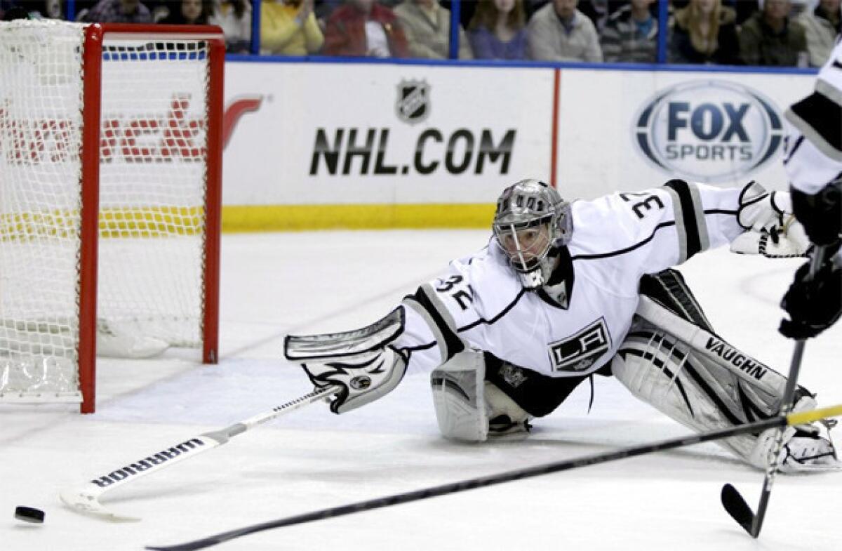 Kings goalie Jonathan Quick (32) pokes the puck away with his stick.