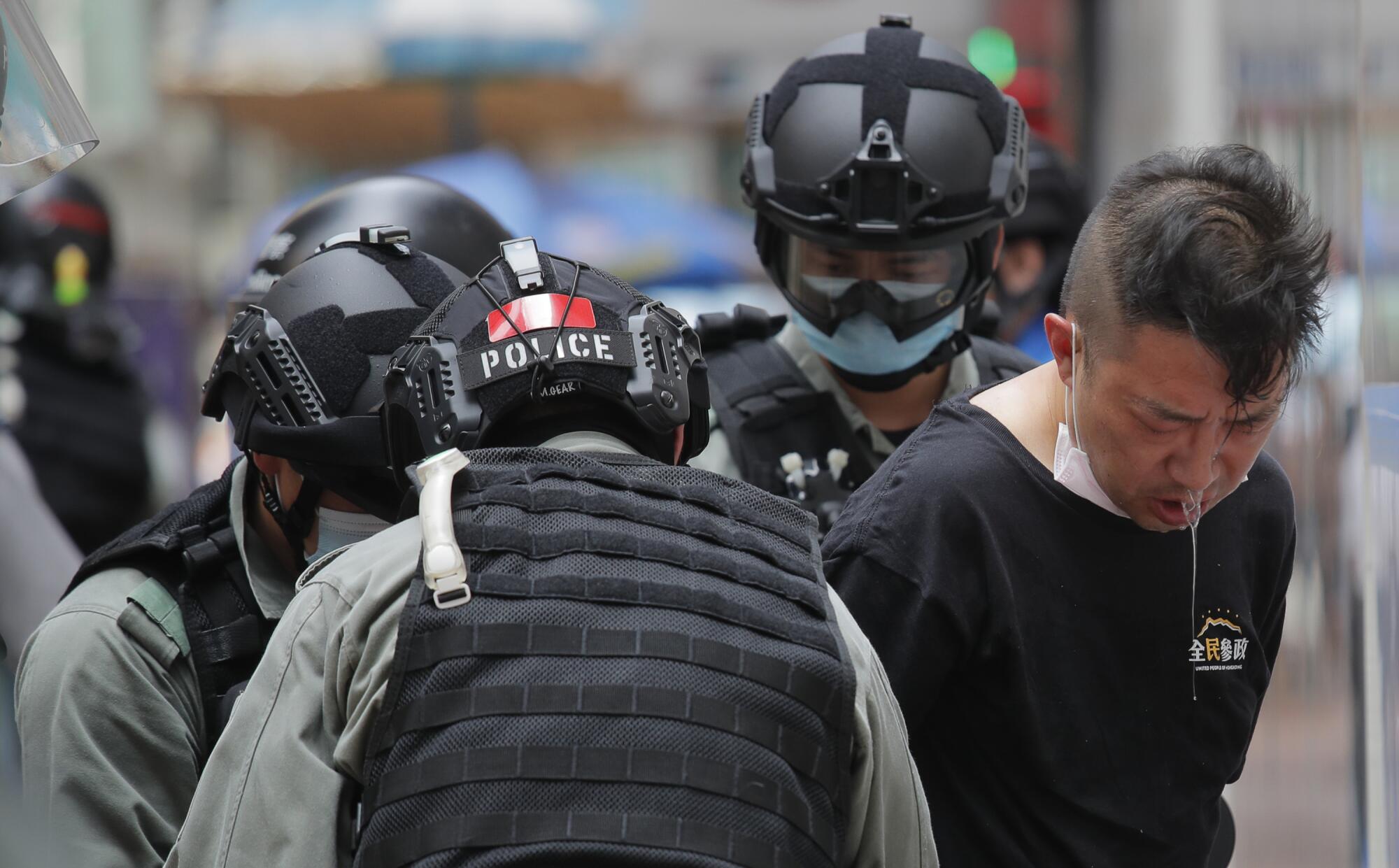 A protester who had been pepper sprayed is detained by Hong Kong police during Wednesday's protest.