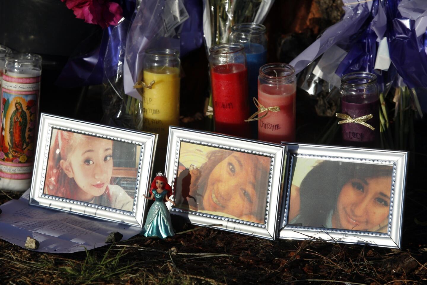 Flowers, candles, letters and photos are left at the crash site in Newport Beach. From left in the framed photographs are crash victims Robin Cabrera, Aurora "Christine" Cabrera and Cecilia D. Zamora. All three attended Irvine High School.