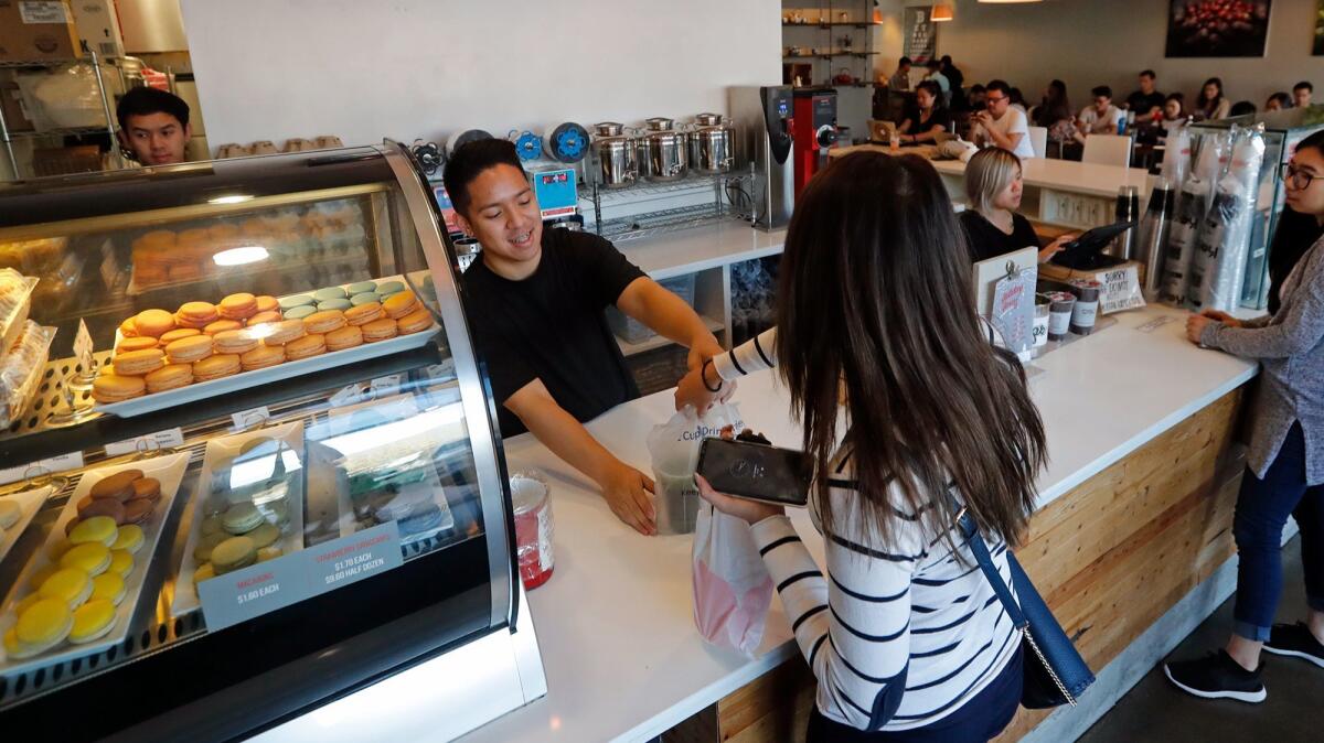 Andy Ho fills a customer's order at 7 Leaves Cafe in Garden Grove.