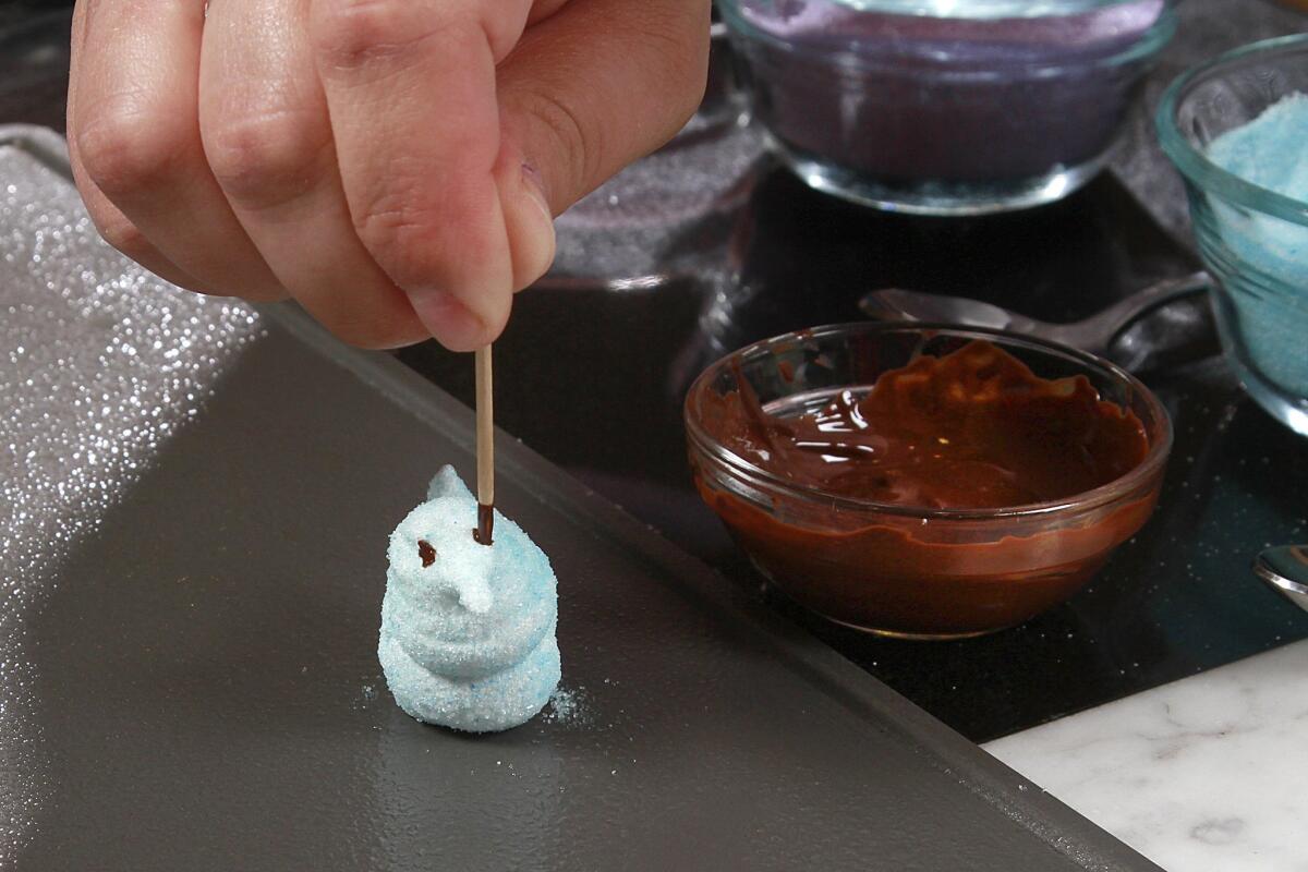 Dotting chocolate "eyes" on a homemade marshmallow chick.