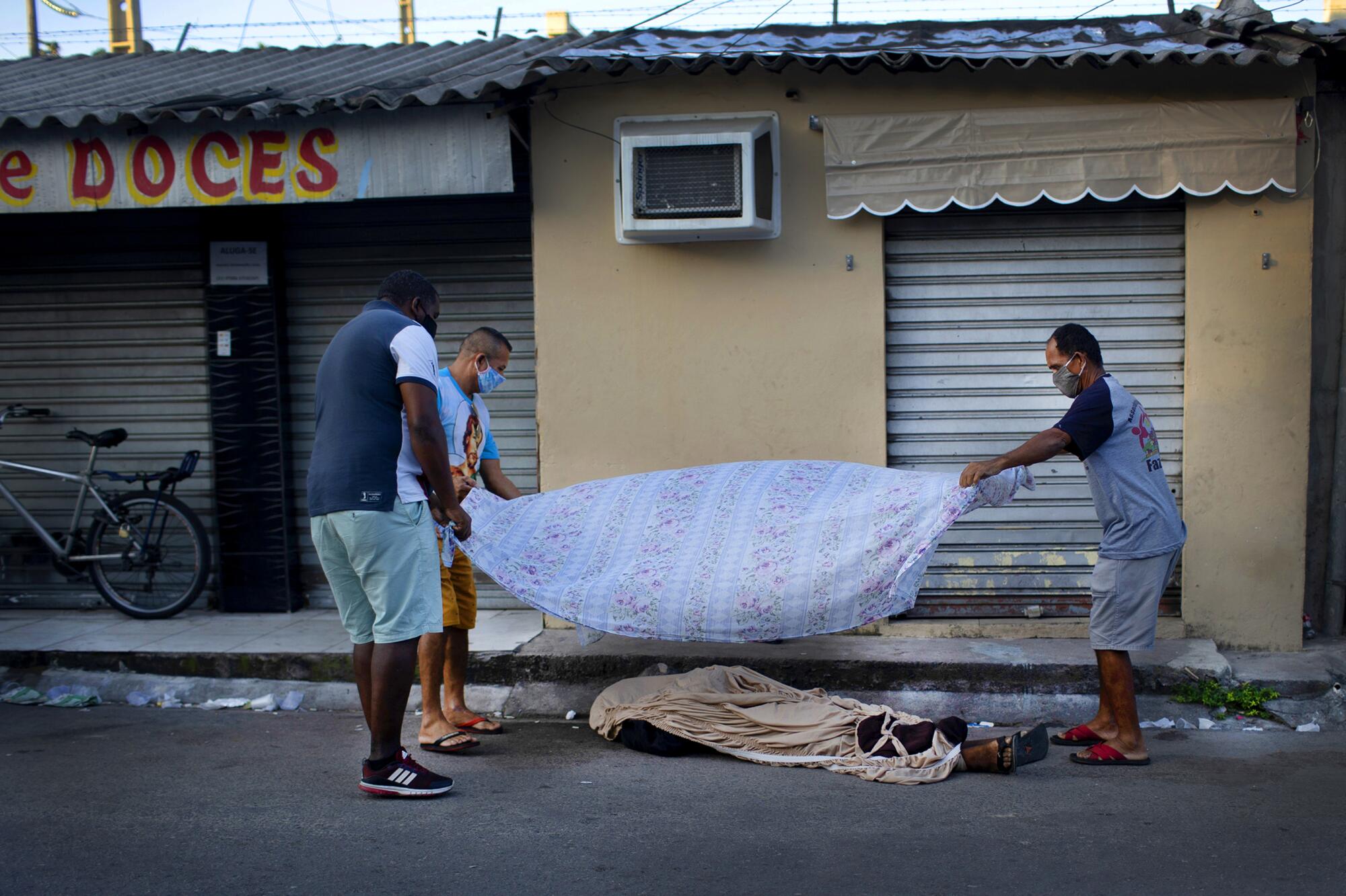 Neighbors cover the the body of 36-year-old Luiz Carlos Da Rocha, who died April 28 in Rio de Janeiro.