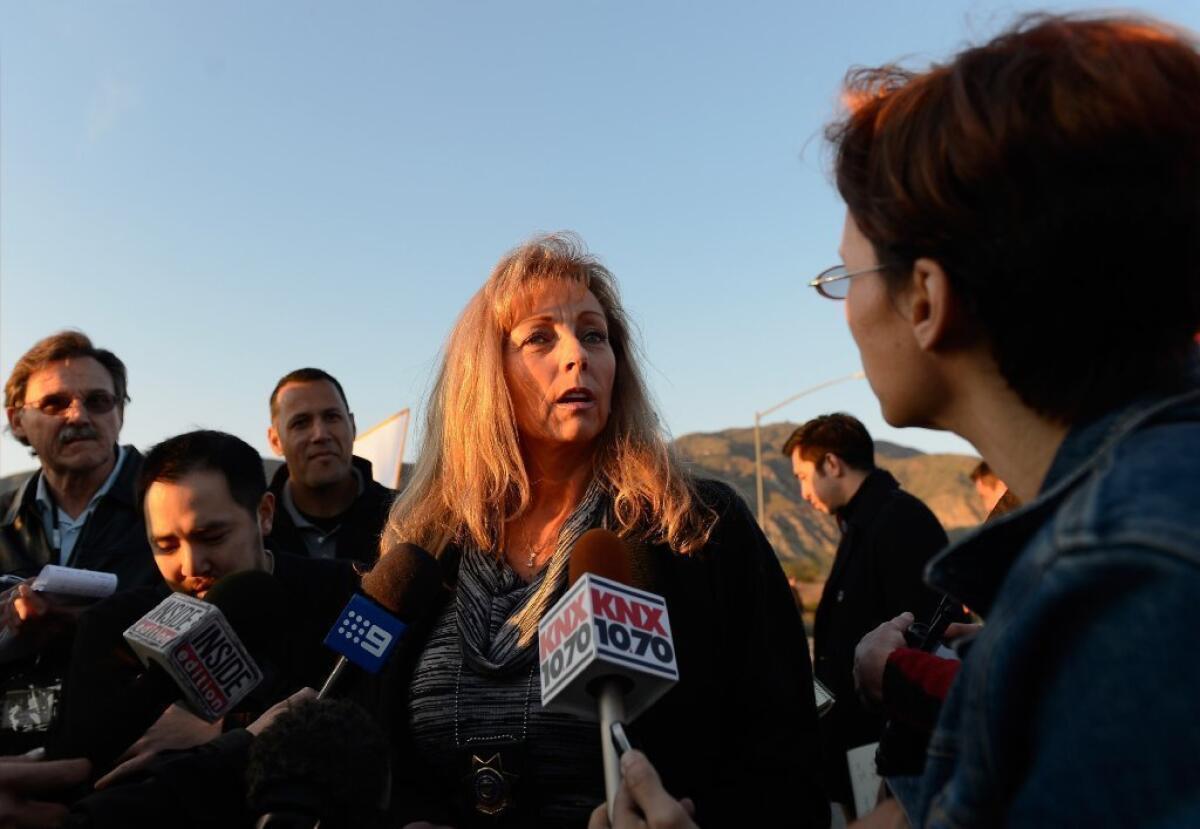 Cindy Bachman, public information officer for the San Bernardino Sheriff's Department, updates the media at a checkpoint manned by Redlands police.