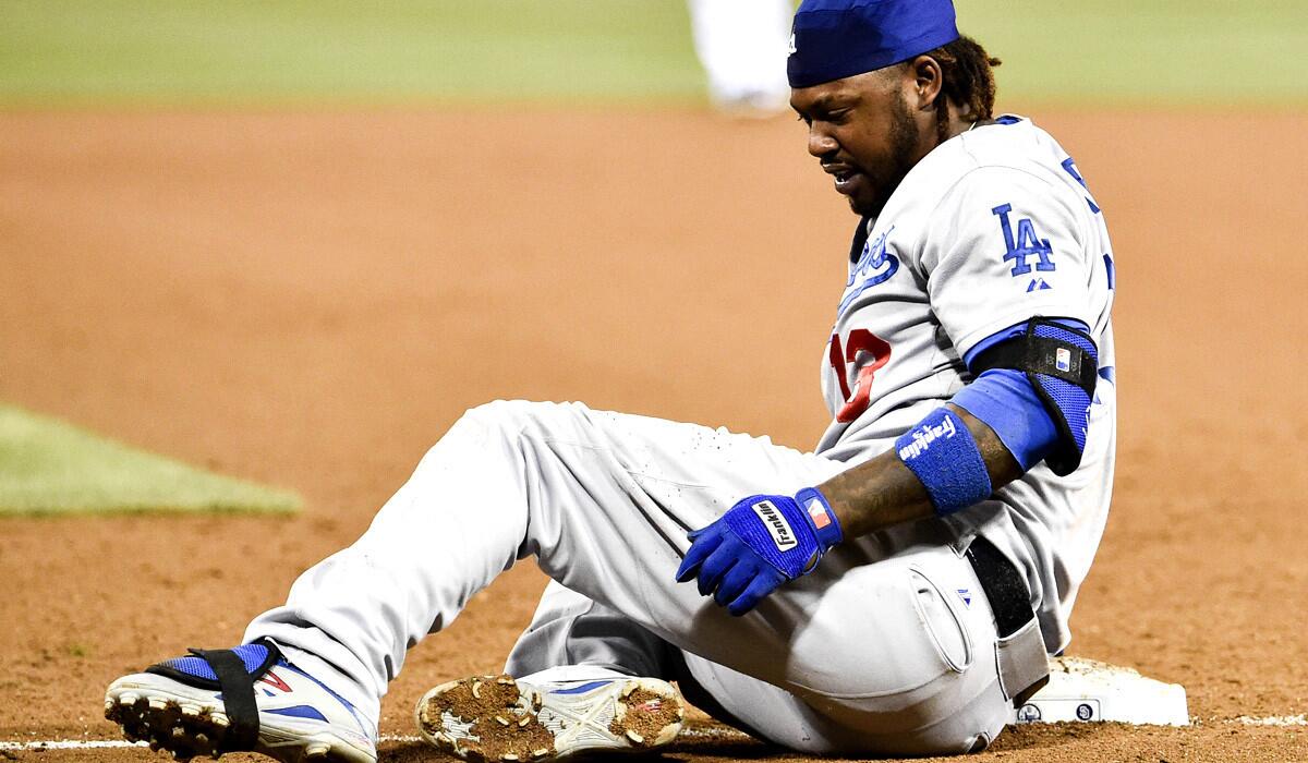 Dodgers shortstop Hanley Ramirez grabs his left leg after stumbling over first base and getting tagged out as he tried to return in the sixth inning Friday night in San Diego.