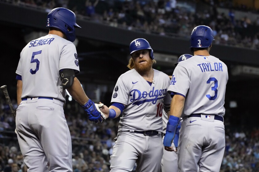 Dodgers' Justin Turner celebrates with Corey Seager and Chris Taylor.
