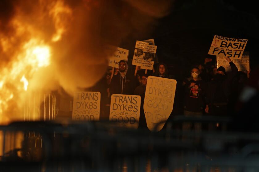 Protesters watch a fire on Sproul Plaza during a rally against the scheduled appearance by Breitbart News editor Milo Yiannopoulos at UC Berkeley.