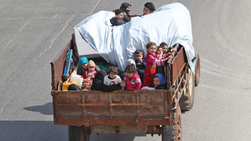 A Syrian family flees from airstrikes by government and Russian warplanes in rebel-held Idlib province on Monday.