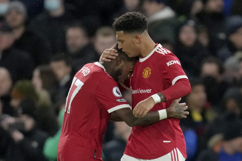 Manchester United's Jadon Sancho celebrates with Manchester United's Fred, left, after scoring the opening goal during the English Premier League soccer match between Chelsea and Manchester United at Stamford Bridge stadium in London, Sunday, Nov. 28, 2021. (AP Photo/Kirsty Wigglesworth)