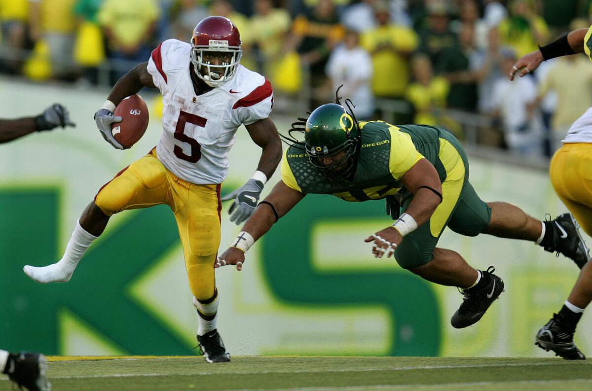 USC running back Reggie Bush eludes Oregon's Matt Toeaina during a game in September 2005.