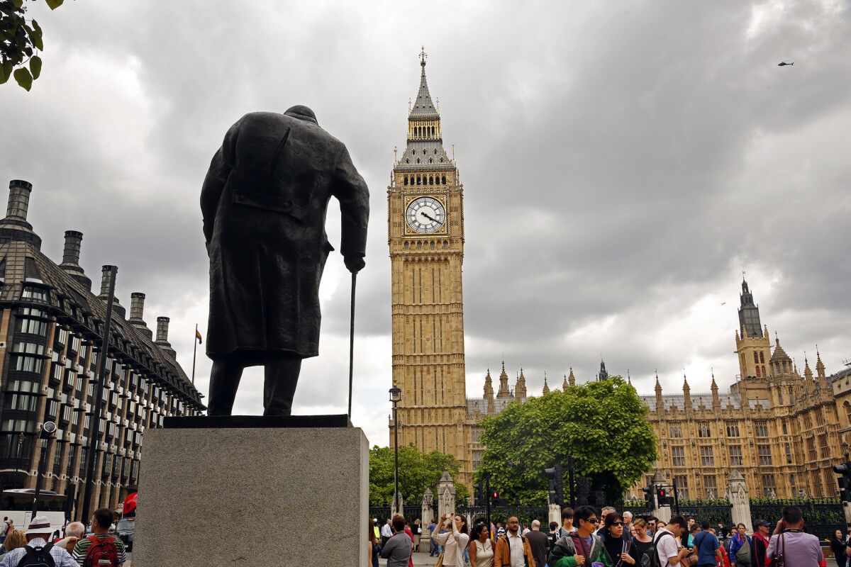 A statue of Winston Churchill stands in the square of the Palace of Westminster in London.