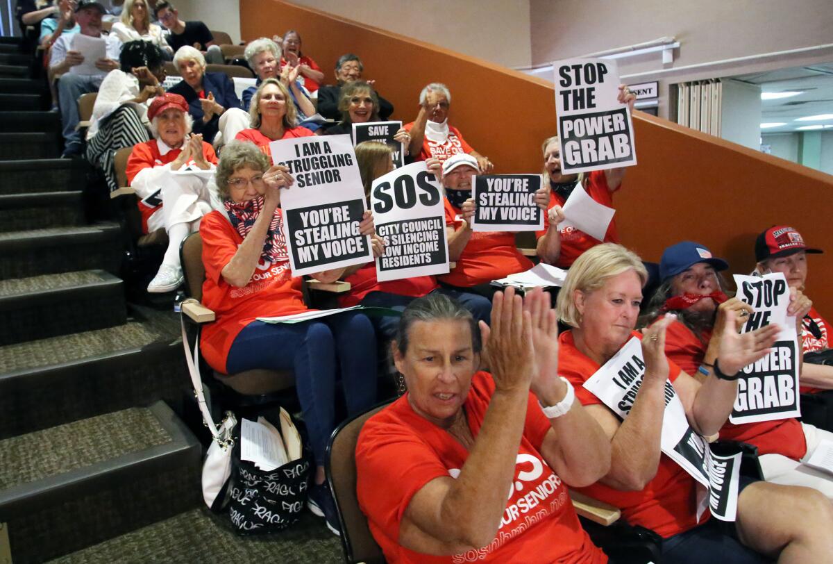 Members of Huntington Beach's Mobile Home Advisory Board cheer for a public speaker Tuesday during a City Council meeting.