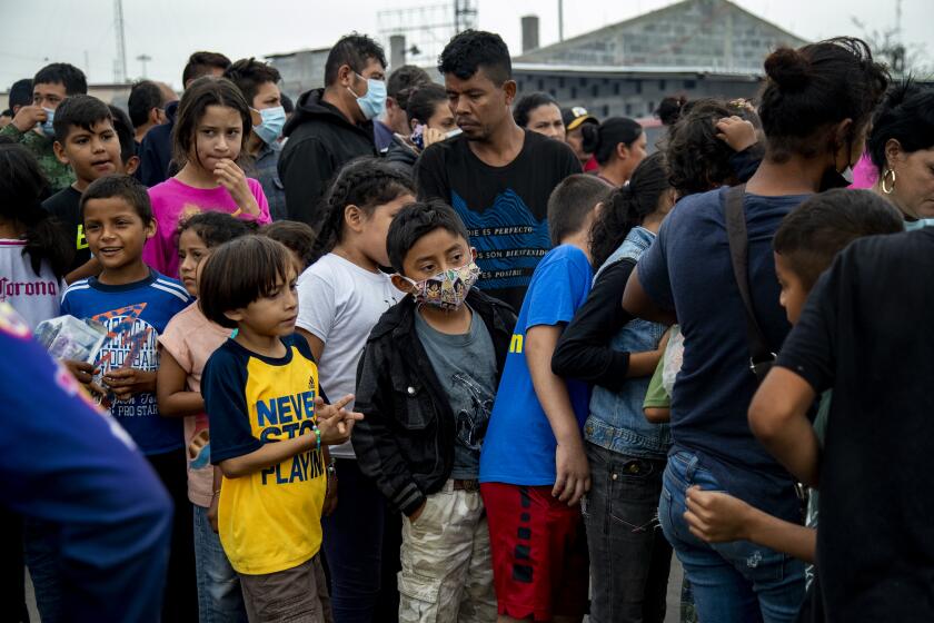 REYNOSA, MEXICO - DECEMBER 6, 2021: Migrant children stand in line for food distribution at the Plaza Las Americas migrant tent camp which currently holds 2,000 migrants on December 6, 2021 in Reynosa, Mexico. (Gina Ferazzi / Los Angeles Times)