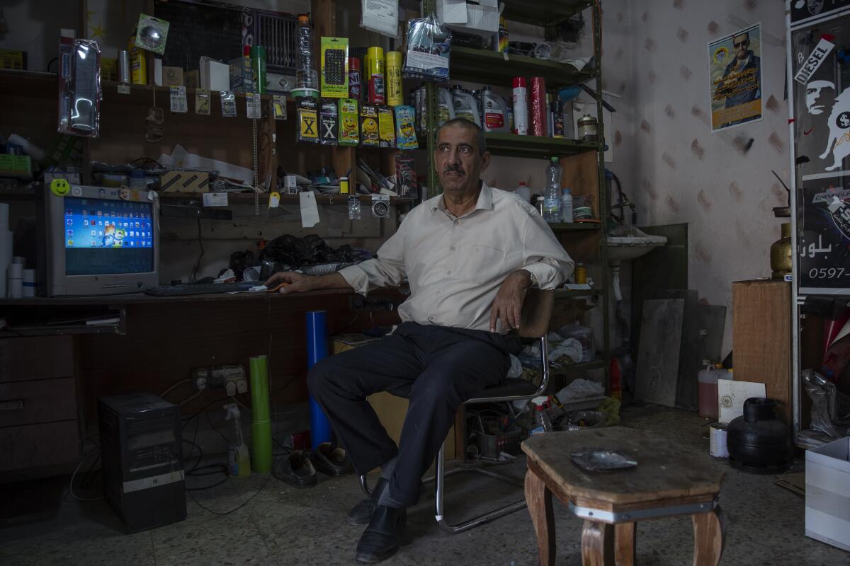 Mustafa Erekat sits inside his shop  in the village of Abu Dis, South of Ramallah