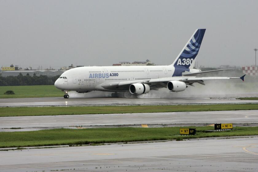 An Airbus super jumbo A380 passenger jet lands at Taiwan's Taoyuan International Airport, Friday, June 8, 2007, in Taoyuan, Taiwan. The world's largest passenger plane arrived at Taoyuan airport in suburban Taipei after a flight from Sydney, its massive wheels kicked up sprays of water from three days of heavy rain that have buffeted this verdant island 160 kilometers (100 miles) off the China coast. (AP Photo/Wally Santana)