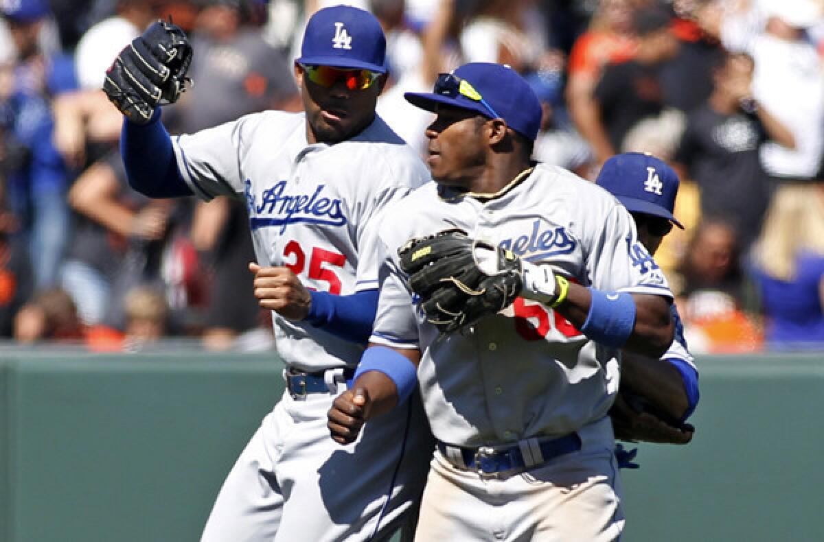Carl Crawford (25) and Yasiel Puig, right, will not be celebrating in the outfield Saturday since both have been scratched from the lineup because of injuries.