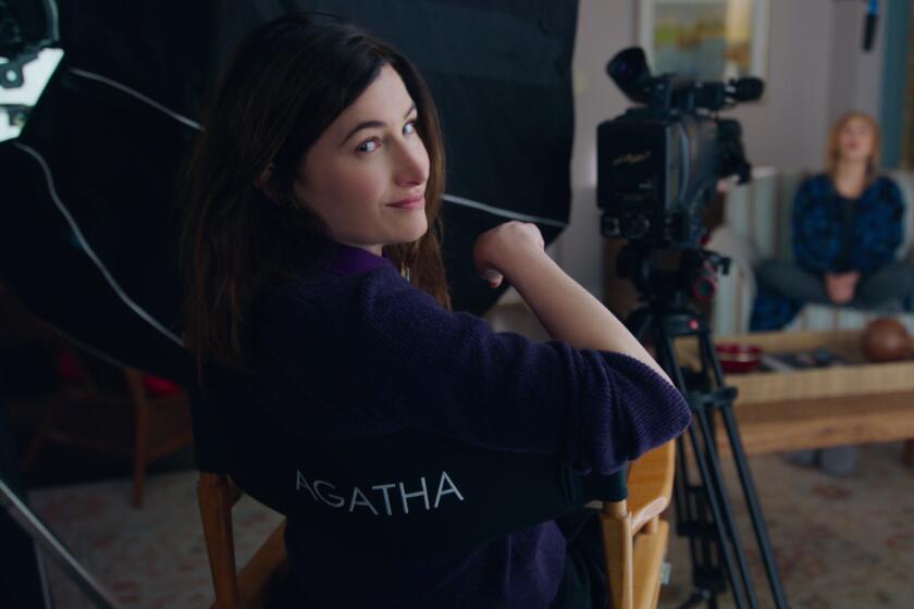 Kathryn Hahn looks over the back of a director's chair that says, Agatha