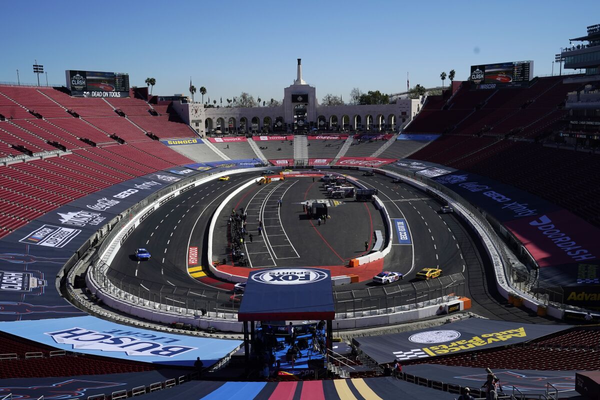 Competitors race around the track during a practice session at the Los Angeles Memorial Coliseum, Saturday, Feb. 5, 2022, in Los Angeles, ahead of a NASCAR exhibition auto race. (AP Photo/Marcio Jose Sanchez)