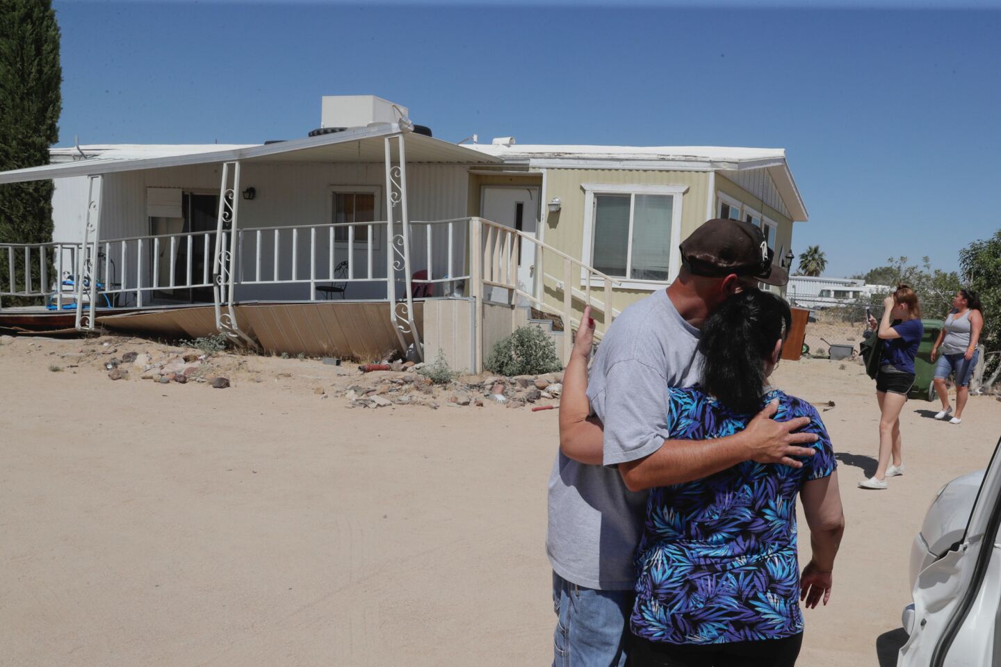 Charles Hawkins, left hugs his mother Elizabeth at his Ridgcrest area mobile home. His wife was injured in the earthquake and his mobile home was damaged.