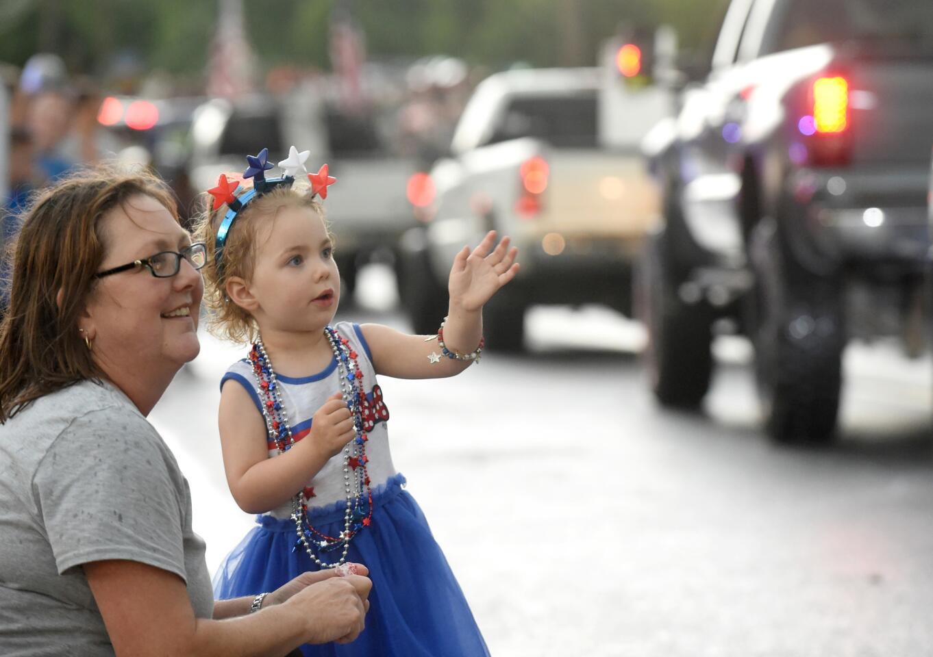 Manchester resident Ruth Pacelli is joined by her 3-year-old granddaughter Clara as they watch vehicles drive by in the parade, leading to the Manchester Volunteer Fire Company carnvial on Tuesday, July 2.