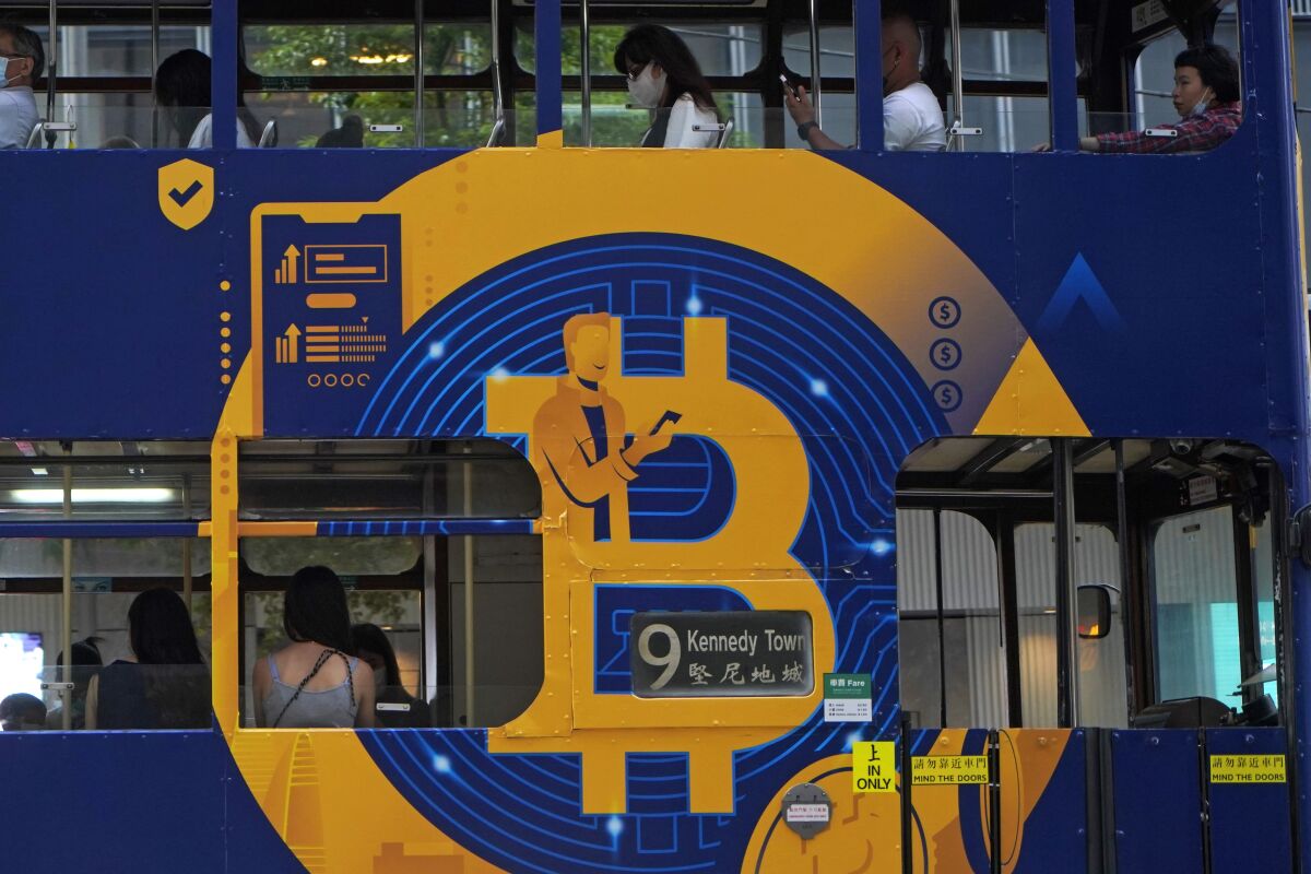 FILE - This May 12, 2021, file photo shows an advertisement for the cryptocurrency Bitcoin displayed on a tram in Hong Kong. As the biggest cryptocurrencies flirt with record highs in value, they are increasingly becoming a bigger source of revenue for charities. However, the number of charities accepting the virtual currencies, known for their volatility, remains limited. (AP Photo/Kin Cheung, File)