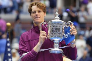 Jannik Sinner, of Italy, holds up the championship trophy after defeating Taylor Fritz.