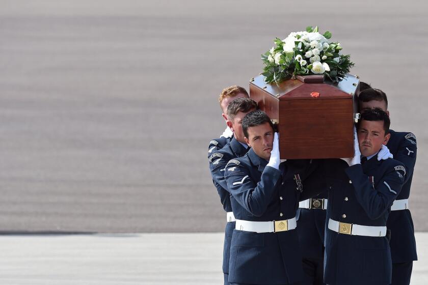 The coffin of Christopher Dyer is carried in Brize Norton, England, on Friday after arriving on a Royal Air Force plane that repatriated the bodies of five British nationals killed in a terrorist attack in Tunisia on June 26.