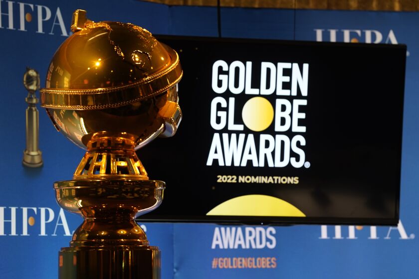 A golden trophy positioned in front of a TV screen that reads "Golden Globe Awards"