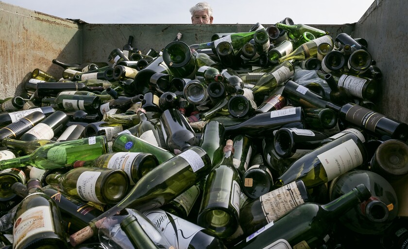 FILE - In this Dec. 10, 2015 file photo more than 500 bottles of counterfeit and unsellable wine are destroyed at the Texas Disposal Systems recycling and compost facility in Austin, Texas. The wine is from the Rudy Kurniawan case, the man convicted of fraud in federal court in 2013 for producing and selling millions of dollars of counterfeit wine. Kurniawan, who bilked wine collectors out of millions by selling cheaper hooch he relabeled in his kitchen has been deported to his native Indonesia. U.S. immigration officials say Kurniawan was deported last week from Dallas/Fort Worth International Airport to Tangerang City. (Rodolfo Gonzalez/Austin American-Statesman via AP,File)