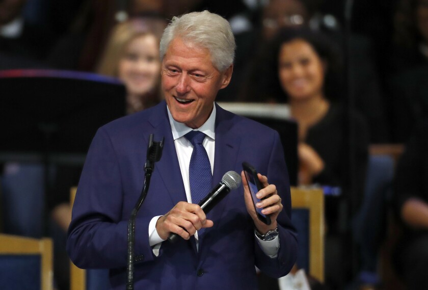 FILE - Former President Bill Clinton smiles as he plays a recording of Aretha Franklin on his phone during the funeral service for Franklin at Greater Grace Temple, Friday, Aug. 31, 2018, in Detroit. The Clinton Health Access Initiative selected Dr. Neil Buddy Shah as its new CEO Thursday, April 14, 2022, a sign of the global health organization’s move towards growth in low- and middle-income nations and use of new philanthropic efforts to help fund the expansion. (AP Photo/Paul Sancya, File)
