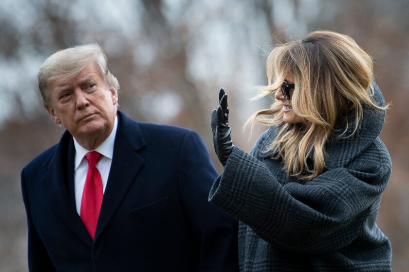 President Trump and First Lady Melania Trump walk from Marine One as they return to the White House on Dec. 31.