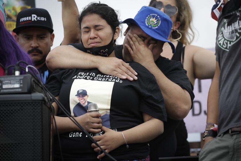 Jennifer Guardado, center left, sister of Andres Guardado, cries as she speaks, while her cousin Steve Abarca holds her during a protest in honor of Andres Guardado on Sunday, June 28, 2020, in Gardena, Calif. Guardado was shot and killed on June 18 by a Los Angeles County sheriff's deputy near Gardena. Patrolling deputies said they saw Guardado talking to someone in a car that was blocking a driveway and that Guardado had a gun when he saw deputies and began to run, leading to a chase and the shooting. (AP Photo/Marcio Jose Sanchez)