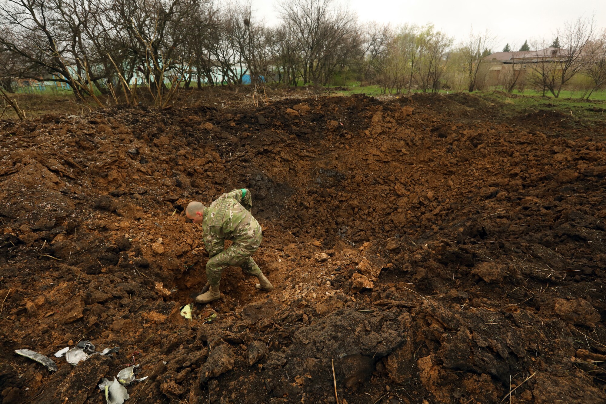 A soldier digs in a giant hole.