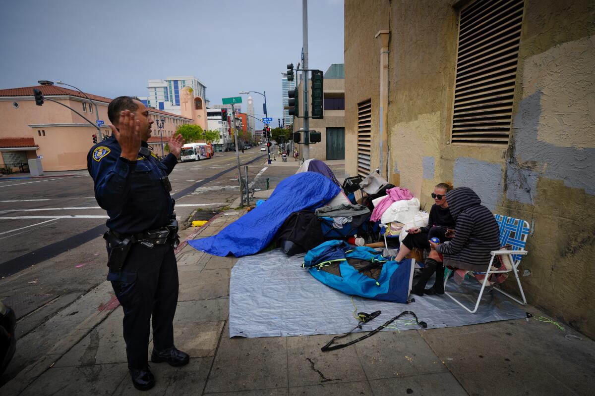 La policía de San Diego indica a Dianna Hinojosa, izquierda, y a Roberta Vianna que deben abandonar la esquina 