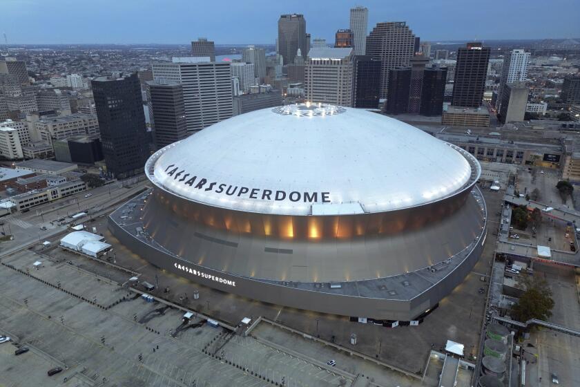 An aerial overall exterior general view of Caesars Superdome with the New Orleans skyline in the background.