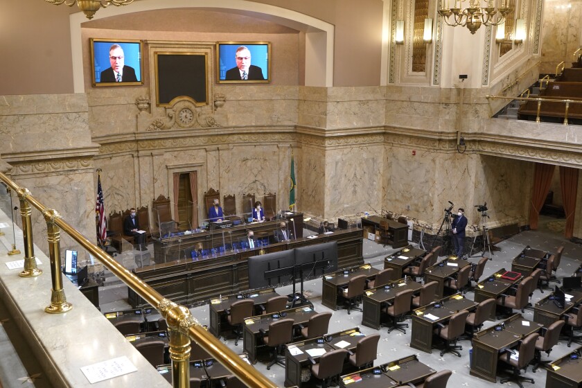 FILE - House Republican Leader J.T. Wilcox, R-Yelm, is displayed on video screens as he speaks remotely following opening remarks from House Speaker Laurie Jinkins, D-Tacoma, during the opening session of the Washington state House, Jan. 10, 2022, at the Capitol in Olympia, Wash. As lawmakers in some Democratic-led states meet remotely because of renewed COVID-19 concerns, their counterparts in many Republican-led legislatures are beginning their 2022 sessions with an aggressive push to outlaw vaccine requirements in workplaces and schools and roll back the government’s power to mandate pandemic precautions. (AP Photo/Ted S. Warren, File)