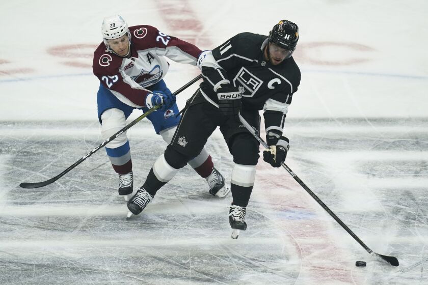 Colorado Avalanche center Nathan MacKinnon (29) defends against Los Angeles Kings center Anze Kopitar (11) during the first period of an NHL hockey game Thursday, Jan. 21, 2021, in Los Angeles. (AP Photo/Ashley Landis)