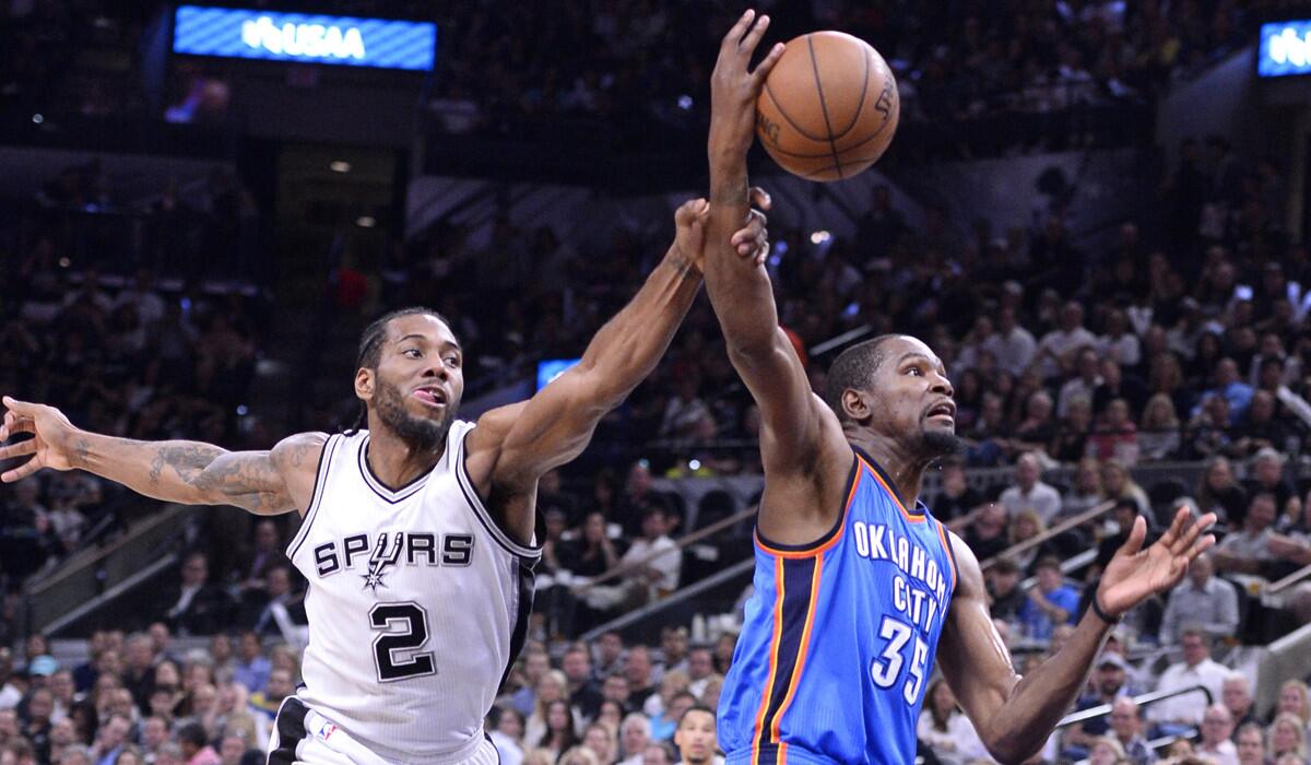 Oklahoma City Thunder's Kevin Durant, right, gets a shot blocked and fouled by San Antonio Spurs' Kawhi Leonard in the first half of Game 5 of the Western Conference Semifinals on Tuesday.