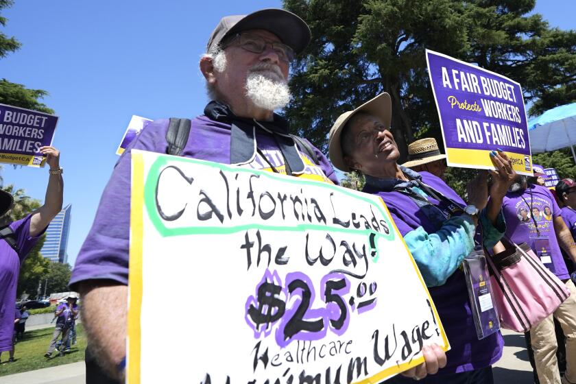 ARCHIVO - Los jubilados Ron Martin, a la izquierda, y Willie Mae Hampton, a la derecha, se suman a otros simpatizantes del Sindicato Internacional de Trabajadores de Servicios en una manifestación contra los recortes presupuestarios propuestos a los programas de la red de seguridad social proporcionados por el estado, el martes 11 de junio de 2024, en Sacramento, California. (AP Foto/Rich Pedroncelli, Archivo)
