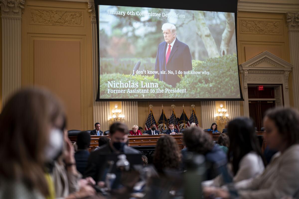 President Trump is seen outside the White House on a large screen displayed above members of the House Jan. 6 committee