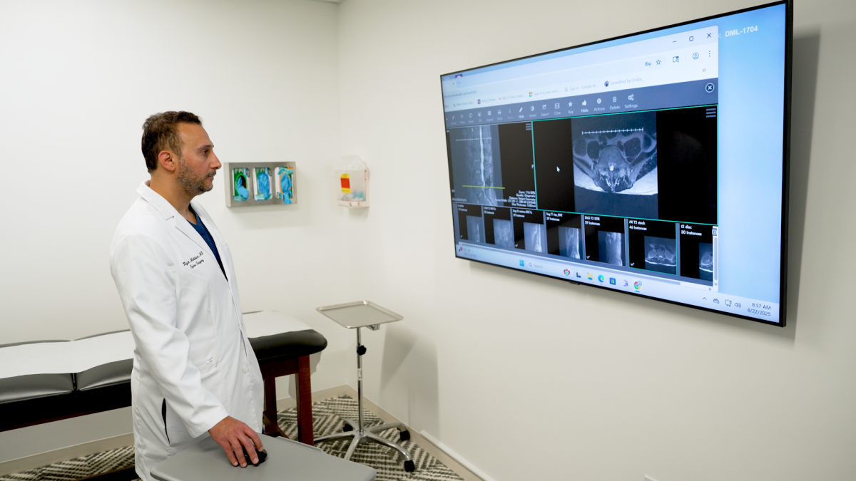 Dr. Rojeh Melikian reviews a patient's lumbar imaging at DISC Surgery Center.