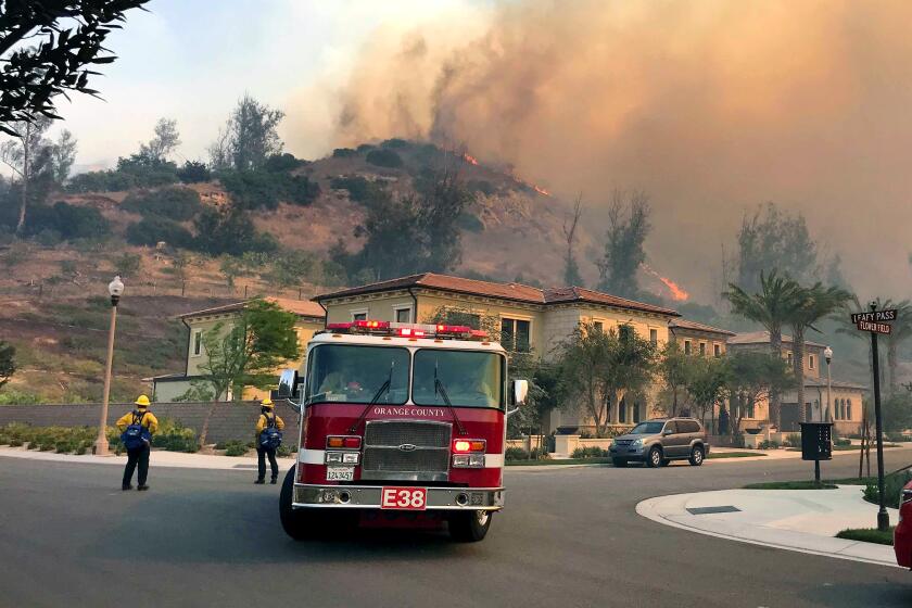 Firefighters do structure protection for homes in Irvine as the Silverado fire continues to burn