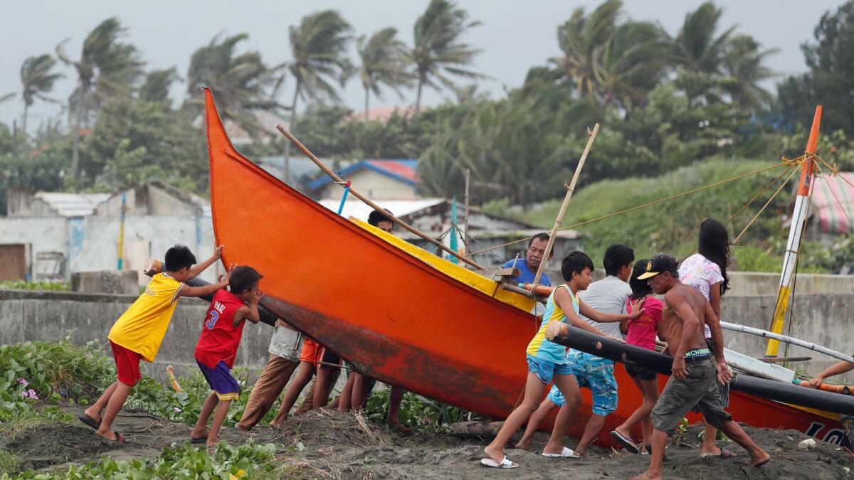 Filipinos secure a boat in the town of Aparri, Cagayan province, Friday as Typhoon Mangkhut bears down.