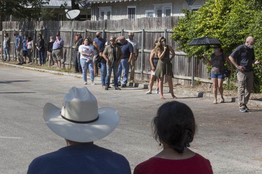 Citizens wait in line to vote early in the general election outside the Comal County Election Office in New Braunfels, Texas.