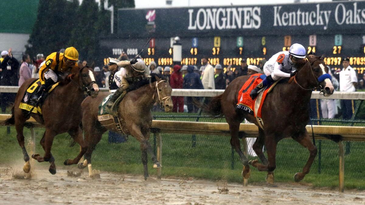 Justify, with Mike Smith aboard, nears the finish line ahead of Audible (5) and Good Magic (6) during the Kentucky Derby on Saturday.