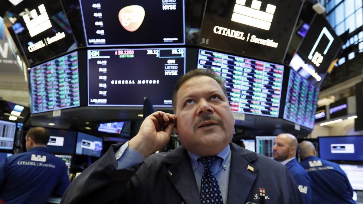 Trader John Santiago works on the floor of the New York Stock Exchange on March 18.